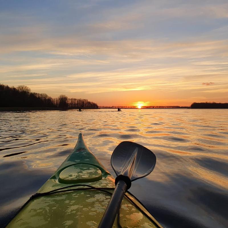 Uitzicht op zonsondergang vanuit een kano op kindervakantie