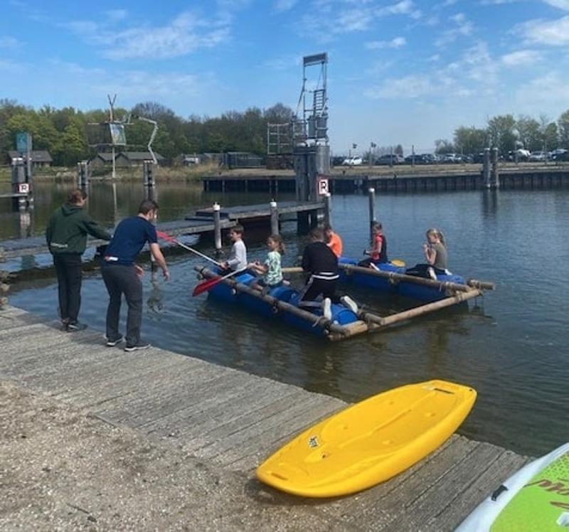 Kinderen varen op een vlot op kindervakantie