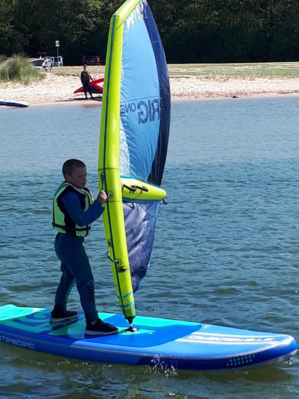 Jongentje leert windsurfen op kindervakantie