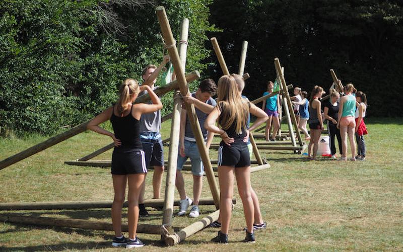 Kinderen maken een constructie uit hout op kinderkamp
