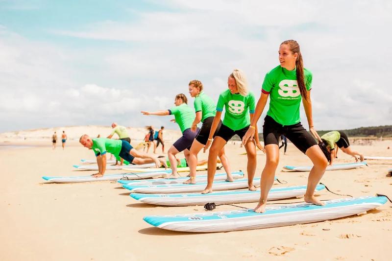 Voordat je het water op gaat krijg je tijdens een surfreis uitleg over technieken jongeren leren tijdens een surfreis hoe ze op een surfplank moeten staan
