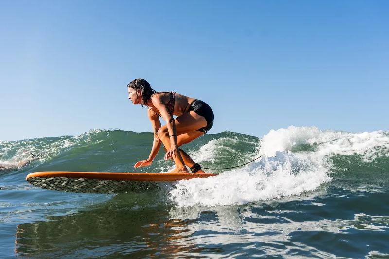 Tijdens een surfreis glijdt je over de golven meisje surft over golf tijdens surfreis