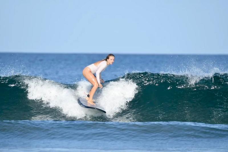 meisje surft over hoge golf tijdens surfreis