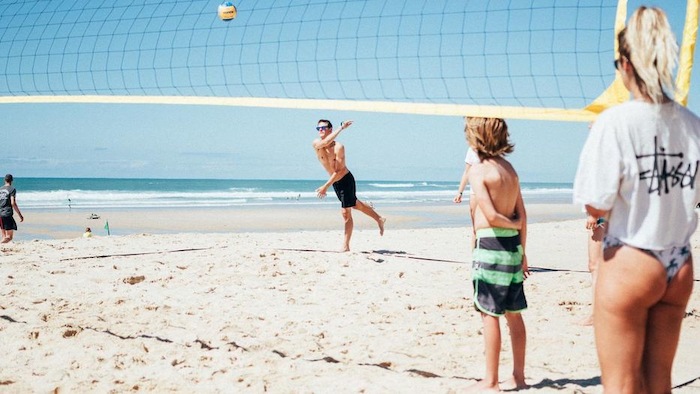Jongeren spelen strandvolleybal op zomerkamp