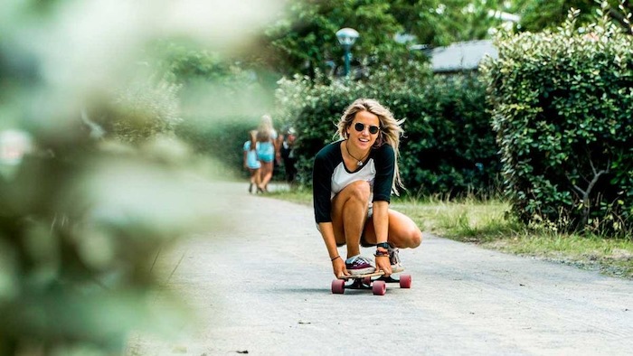 Meisje aan het longboarden op zomerkamp