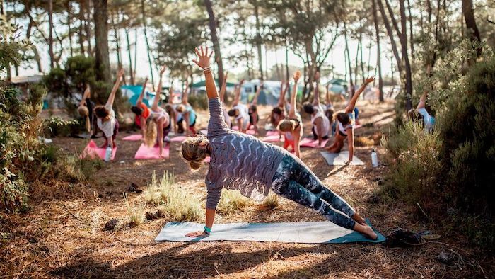 Jongeren staan in yogapose tijdens jongerenreis
