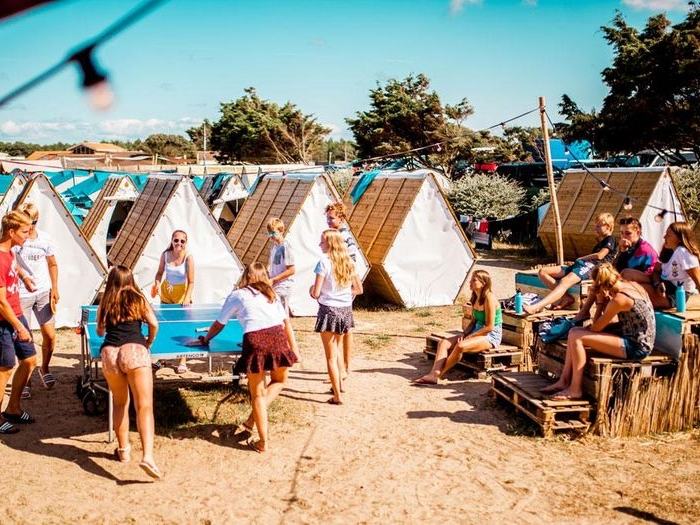 Jongere surft op grote golf tijdens zomerkamp.