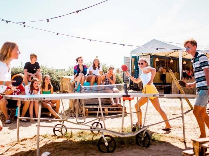 Jongens en meisjes spelen tafeltennis op strandkamp