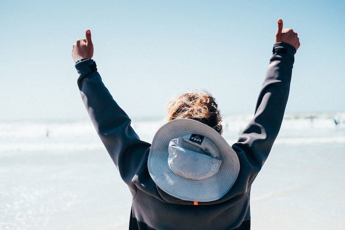 Een jongen is blij tijdnes de groepsreis surfen