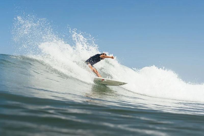 Persoon aan het surfen tijdens een surfkamp 16 jaar