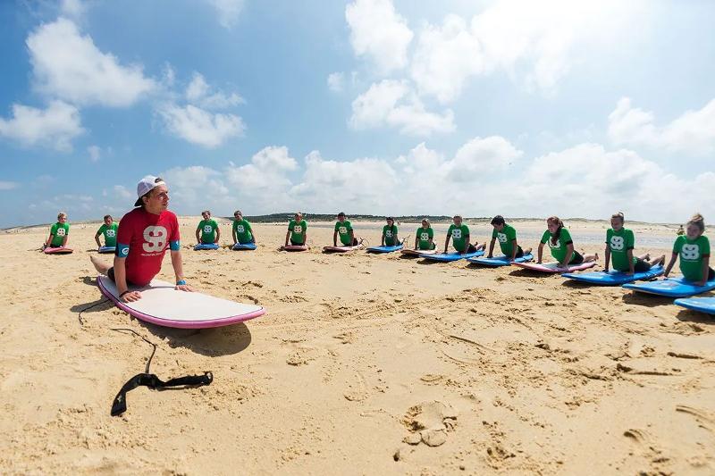 Kinderen die lessen tijdens een surfkamp 16 jaar