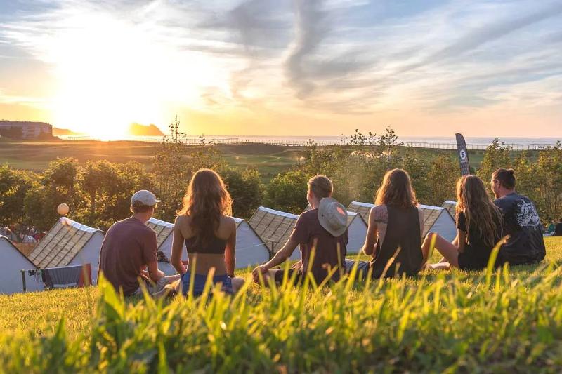 Deelnemers van een surfkamp Zarautz kijken naar een zonsondergang