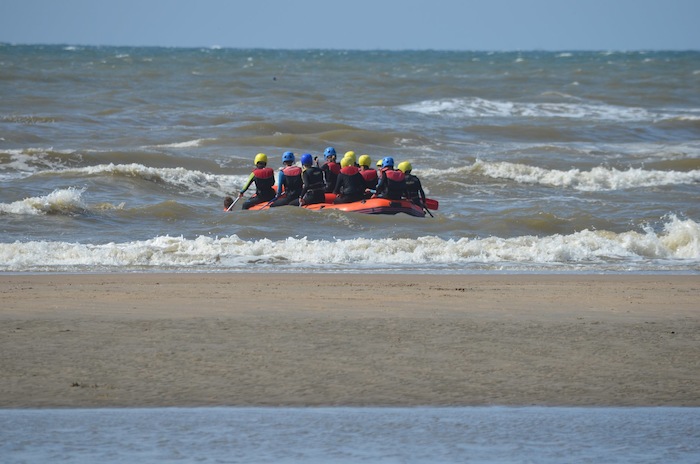jeunes qui font du raft dans la mer en camp sportif ado