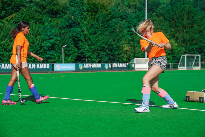 Meisjes spelen hockey op het veld op sportkamp