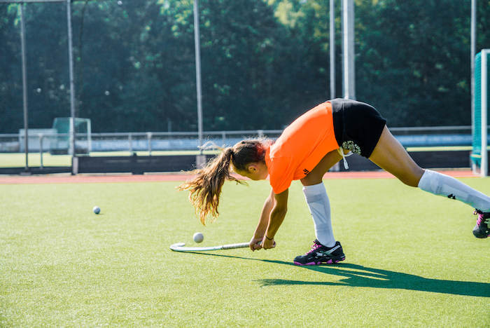 Meisje oefent hockey tricks op sportkamp