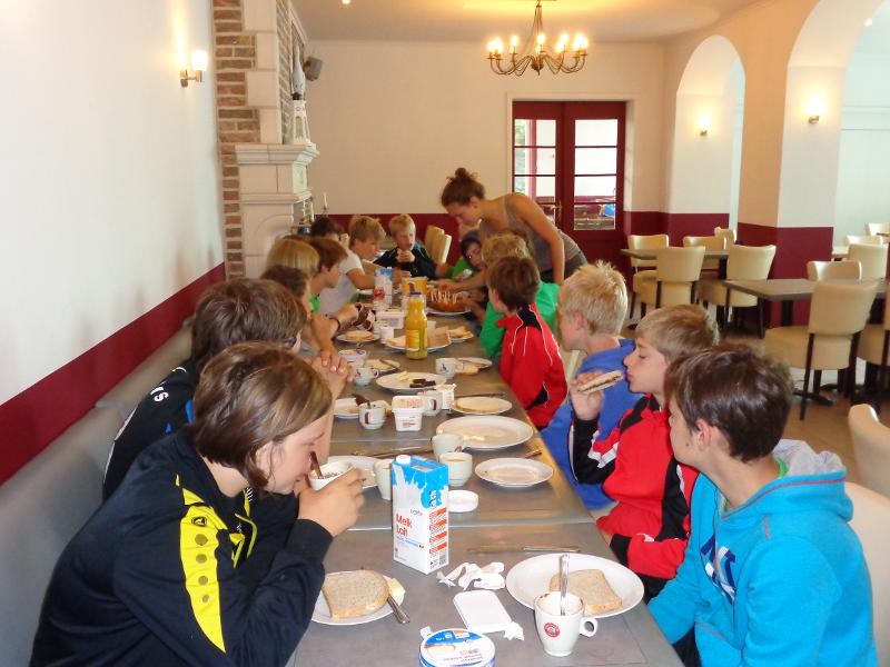 Kinderen lunchen tijdens het sportkamp