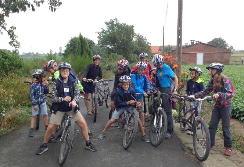 groepje kinderen poseert met mountainbike op tenniskamp