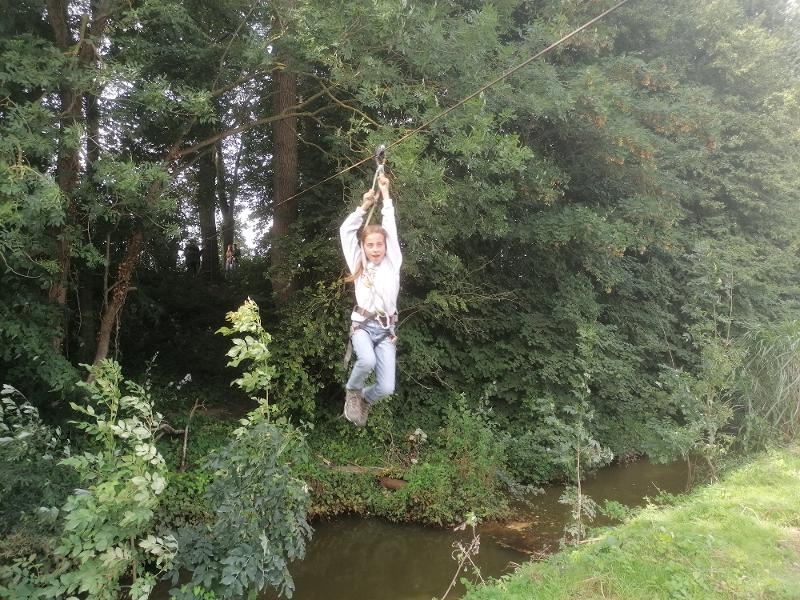 meisje tokkelt over de sloot op tenniskamp
