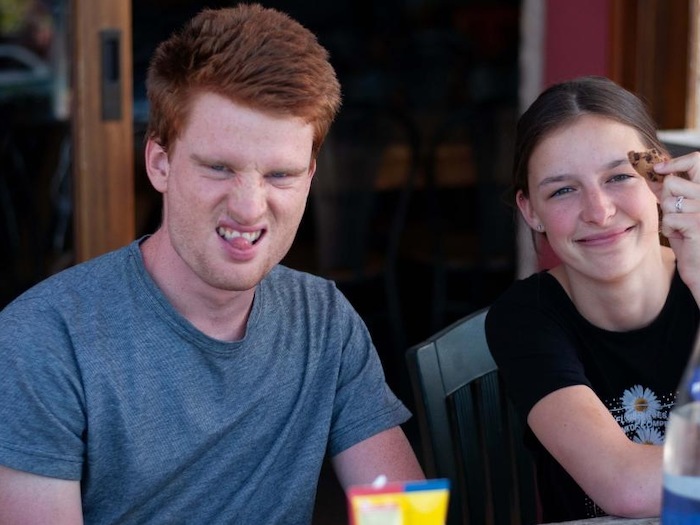 jongen en meisje zitten samen aan het ontbijt en trekken een gek gezicht tijdens theaterkamp in west-vlaanderen