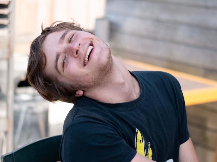 jongen houdt het hoofd schuin en lacht tijdens theaterkamp in west-vlaanderen