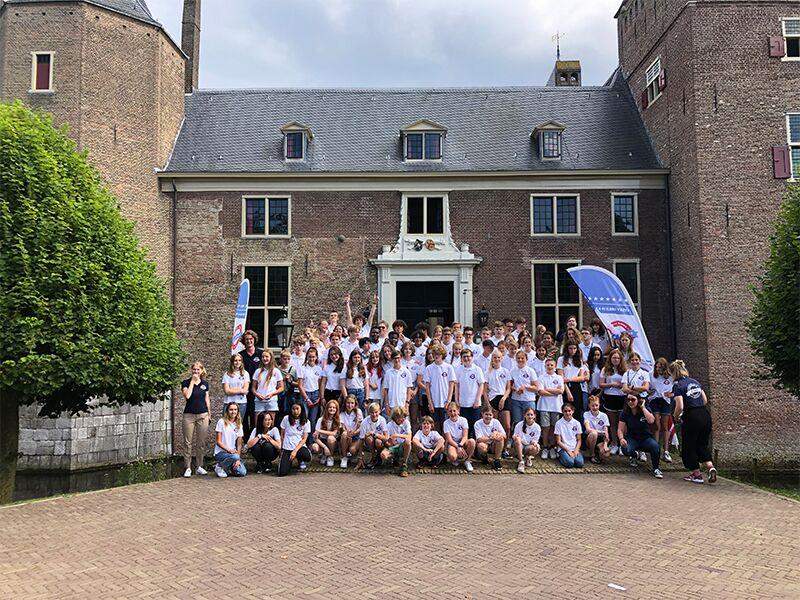 Een groepsfoto van alle deelnemers van een taalvakantie Engels jeugd voor het lesgebouw