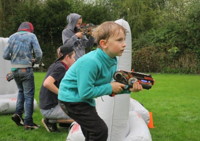 Jongetje schiet met waterpistool tijdens survivalkamp
