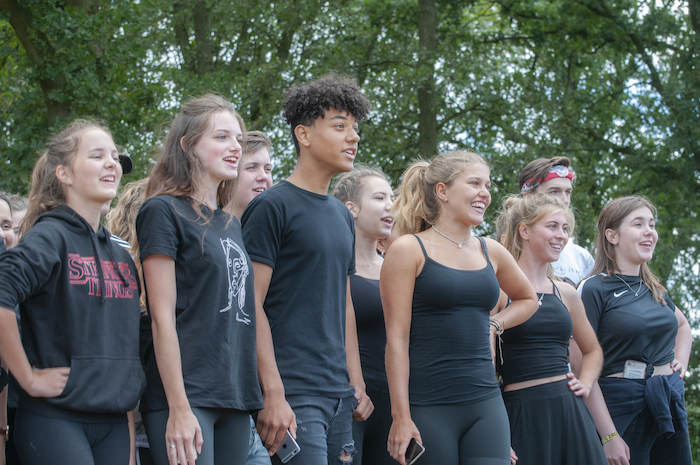 jongens en meisjes in zwarte kleding staan op een rij tijdens theater kamp in noord-brabant