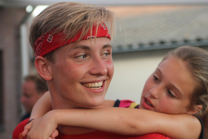 jongen zit op de rug van een jongen met rode hoofdband tijdens theater kamp in noord-brabant