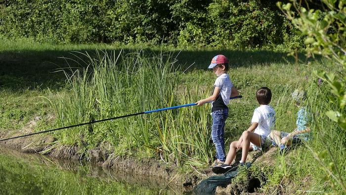 Jongentje met twee vrienden aan het vissen op viskamp