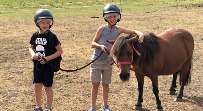 enfants avec un poney et une bombe en colo à la ferme