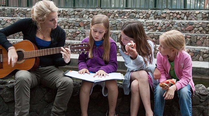 Meisjes leren gitaar spelen op muziekkamp