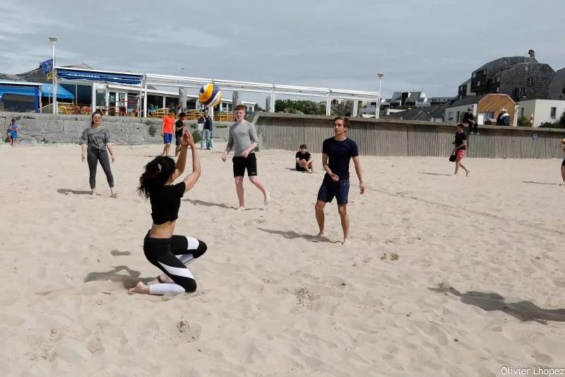 Deelnemers zijn aan het beach volleyballen tijdens de Taalcursussen in Frankrijk