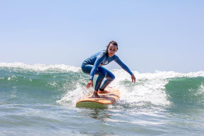 Meid surft in Portugal tijdens de jongerenreis surfen