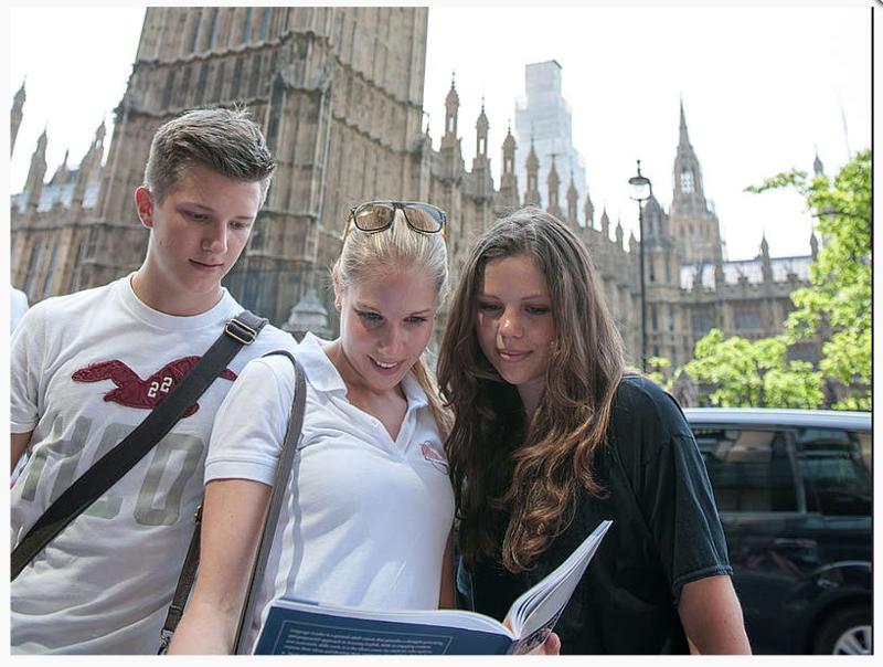 Drie jongeren kijken in een boek in Londen tijdens taalkamp Engeland