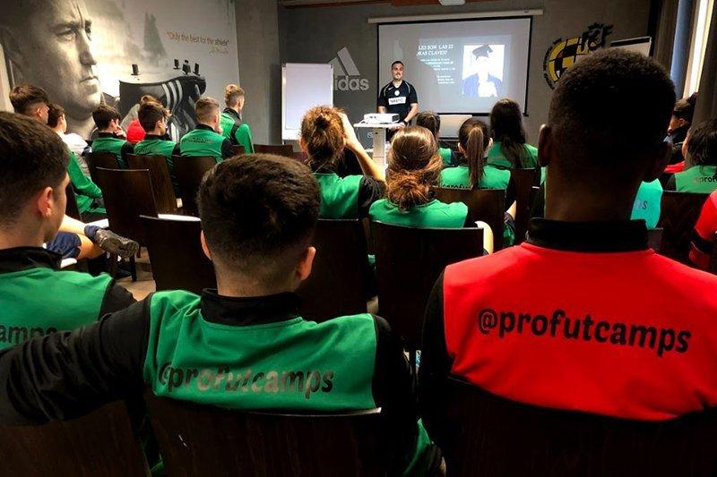jeunes assis qui assistent à une conférence en colonie de vacances foot