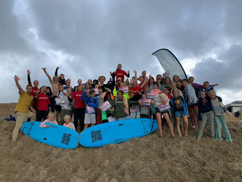 Groepsfoto van jongeren op het strand op jongerenvakantie