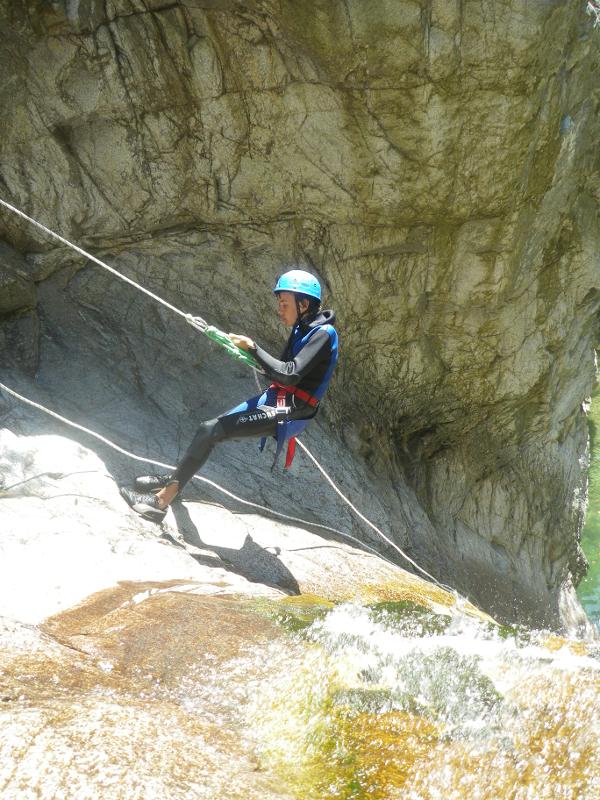 Garçon qui fait de l'escalade avec un casque en colonie aventure