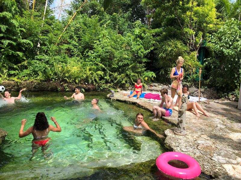 baignade dans une crique avec une bouée rose en camp de vacances surf