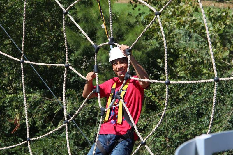 Jongen van 15 jaar hangt in de touwen tijdens een zomerkamp