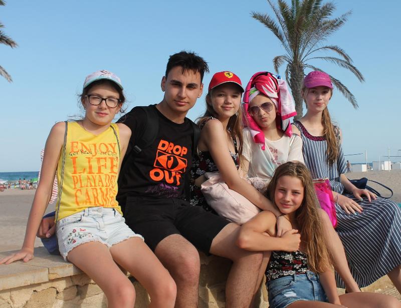 Groepsfoto met vrienden aan het strand tijdens jongerenreis Spanje