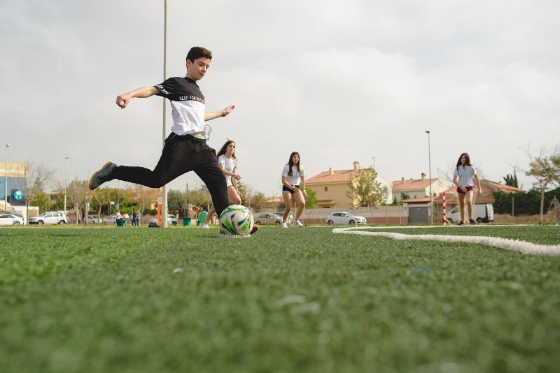 Jongen die aan het voetballen is tijdens jongerenreis Spanje
