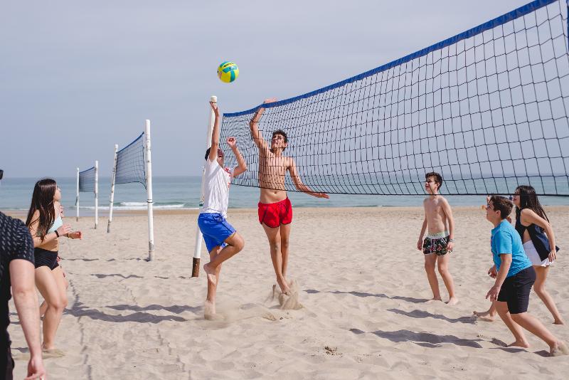 Volleybal spelen op het strand tijdens jongerenreis Spanje
