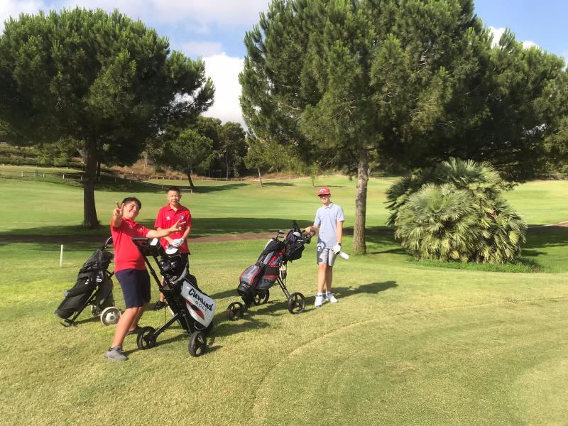 Drie jongens aan het golfen tijdens jongerenreis Spanje