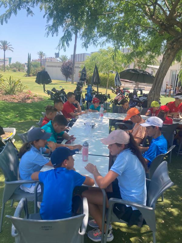 Buiten aan tafel zitten na de golf tijdens jongerenreis Spanje
