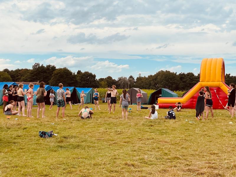 deelnemers doen een buitenactiviteit op het grasveld op een natuurkamp jeugd in zandhoven