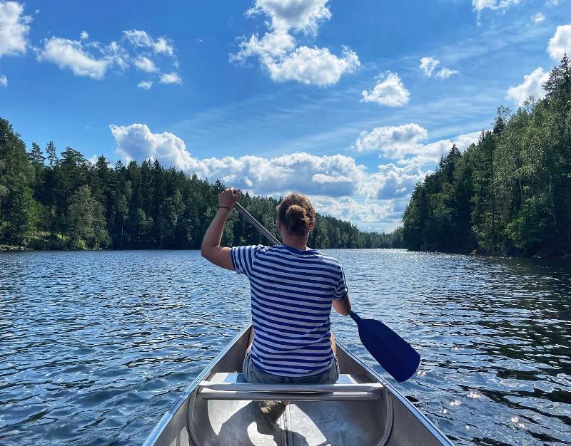 Vrouw aan het kanoën in het meer tijdens natuurkamp in Zweden