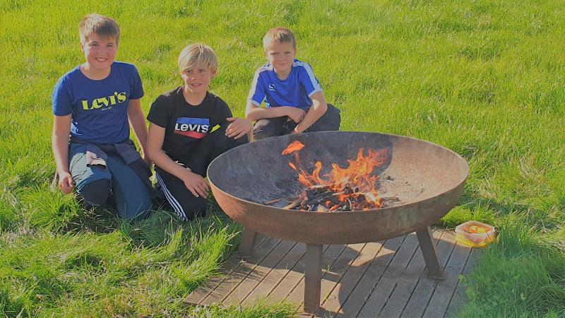 jongens maken kampvuur op boerderij kamp