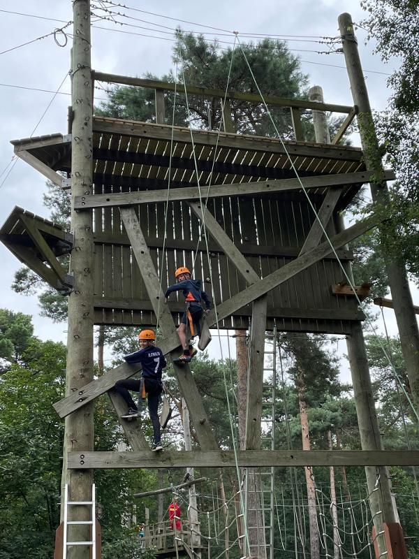 Des enfants qui font de l'escalade sur une installation en bois stage linguistique sportif