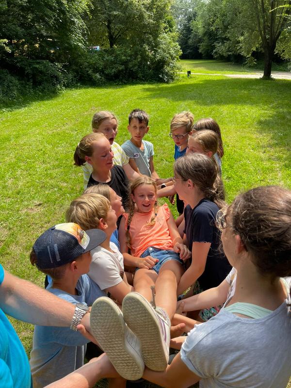 enfants qui portent une fille dans leurs bras en stage linguistique sportif