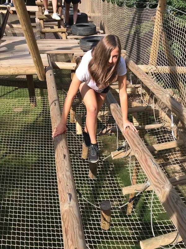 jeune fille qui fait de l'accrobranche en stage linguistique sportif 